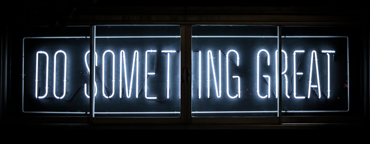 A blue neon sign reading "do something great".