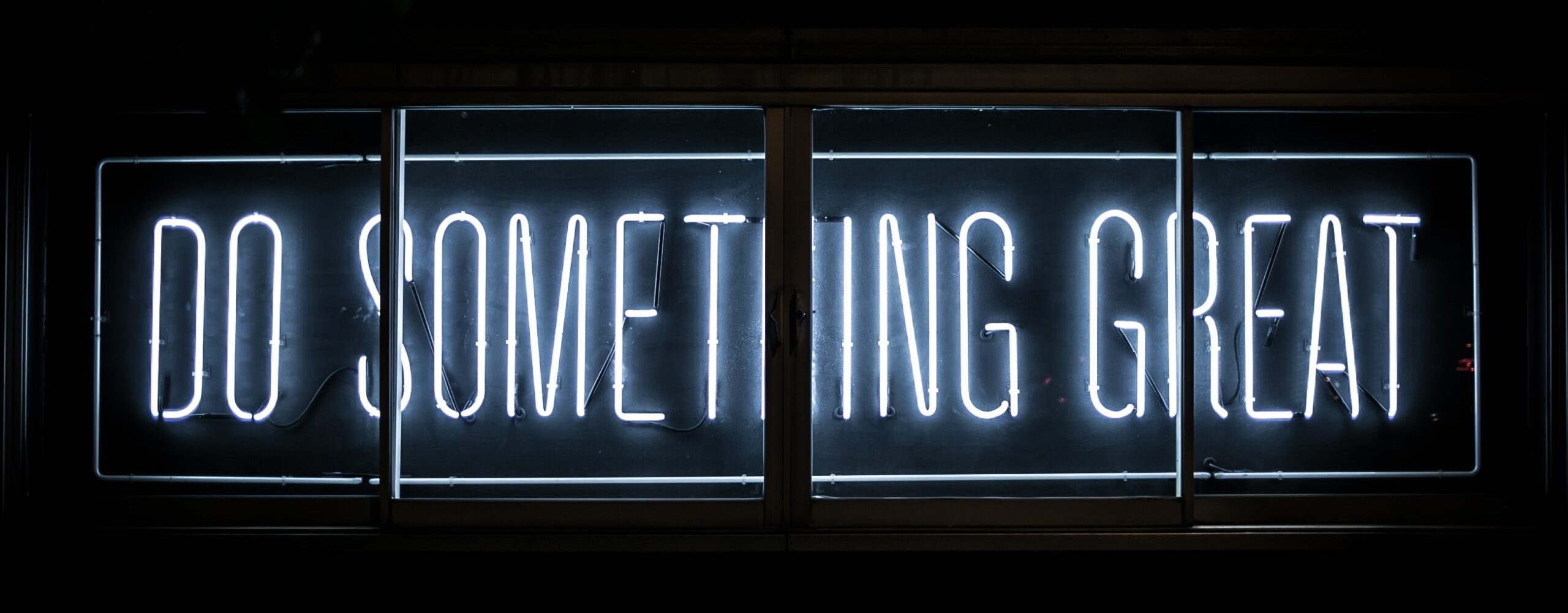 A blue neon sign reading "do something great".